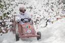 The soapbox from St Joseph's College driving through the foam cloud