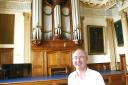 Cllr Nigel Chapman, chairman of Friends of the Moot Hall Organ, in front of the organ.